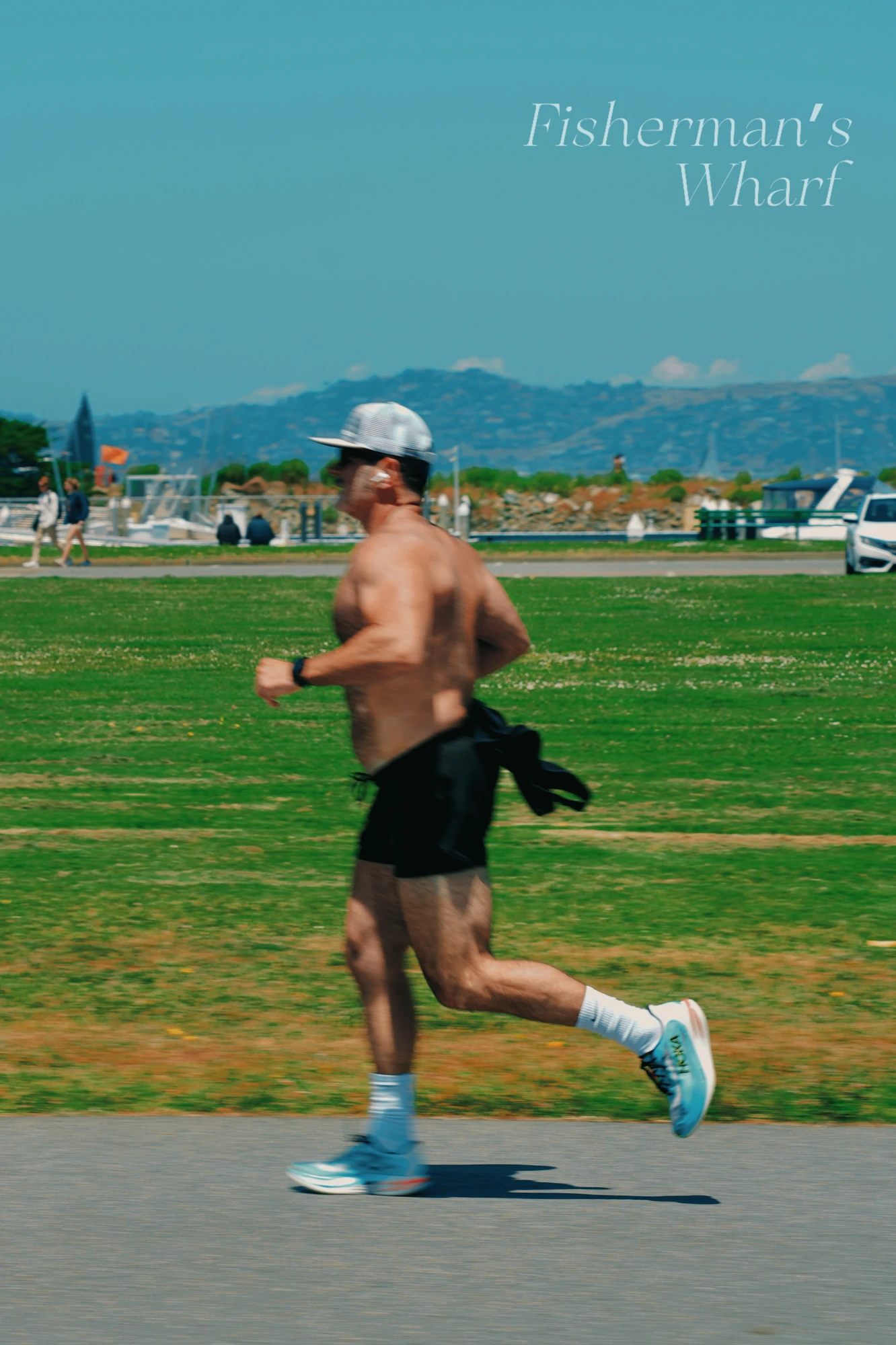 A runner crosses a waterfront lawn, with a title printed on the image.