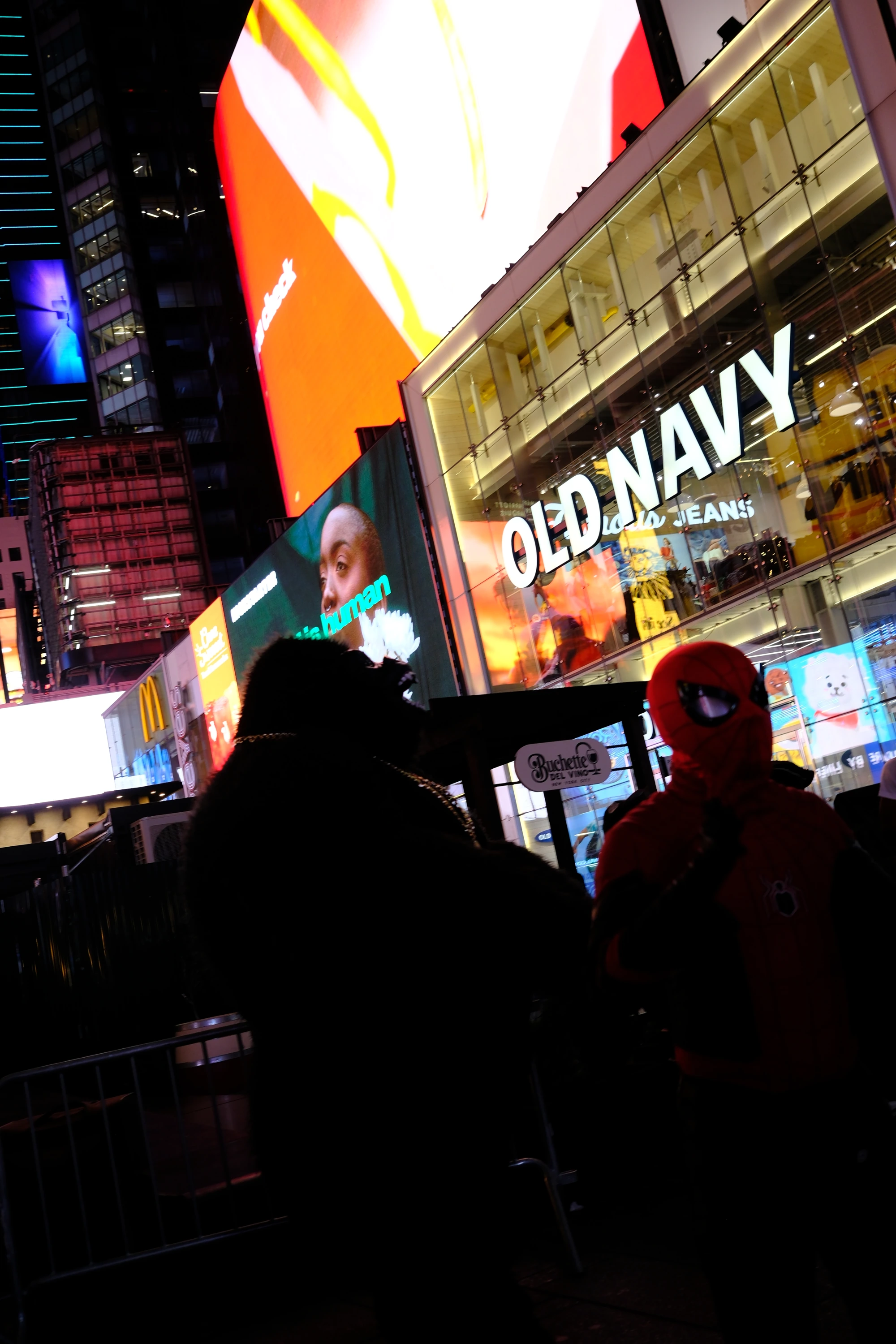 Silhouetted crowds beneath the screens of Times Square.